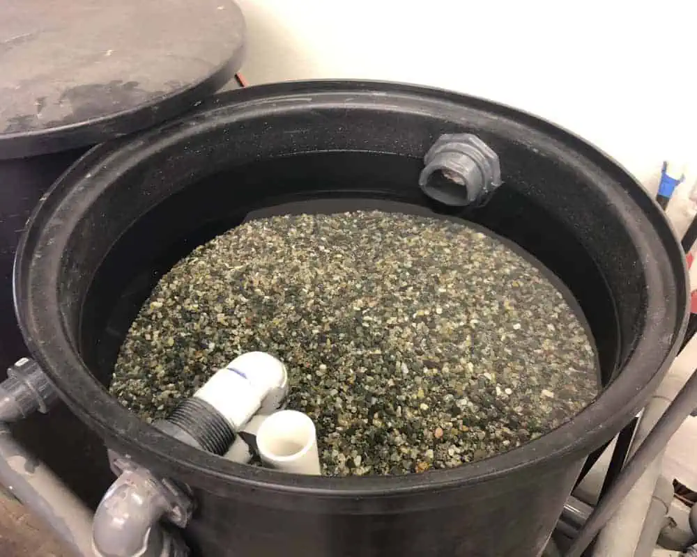 A bucket filled with gravel and water.